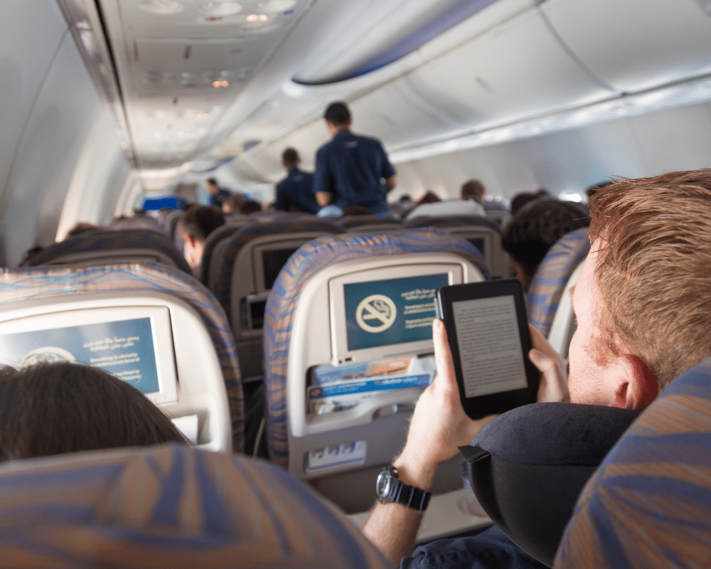 飛行機の中でKindle電子書籍リーダーを読んでいる人